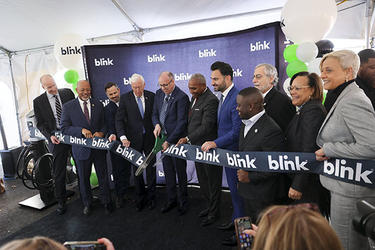 Elected officials and representatives cut the ribbon to ceremonially open the Blink Charging global headquarters
