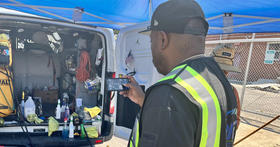 Enforcement inspector takes a picture of the inside of a cleaning van