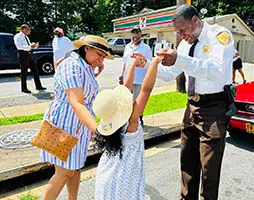 Sheriff Carr talks with a young girl and her mother in the community