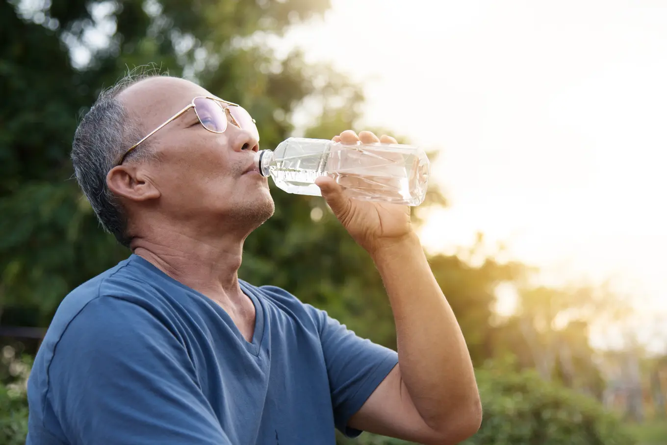 man drinking water on an extremely hot day