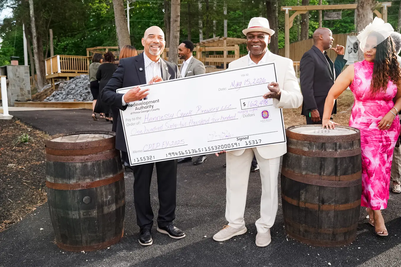 Two individuals holding a big check for the Hennessey Creek Brewery