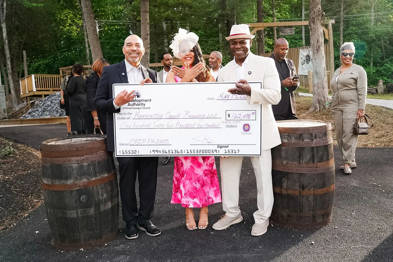 three individuals holding a check for the Hennessey Creek Brewery