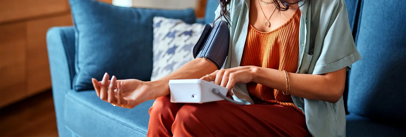 Woman using a Blood Pressue machine.