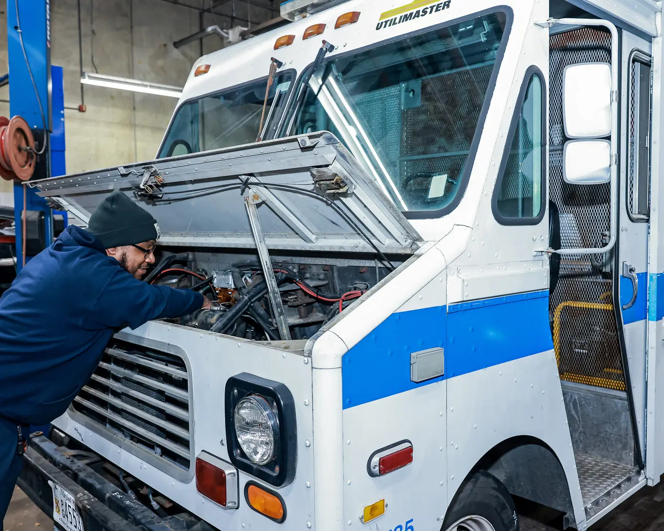 A man working in the engine of a truck for Central Services