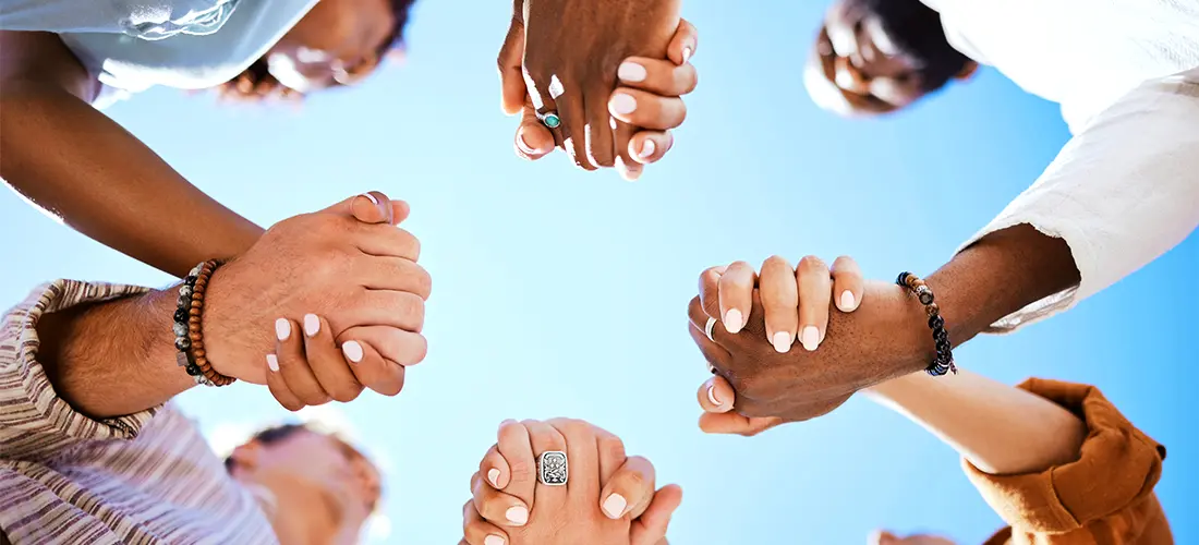 Group of people holding hands in a circle 