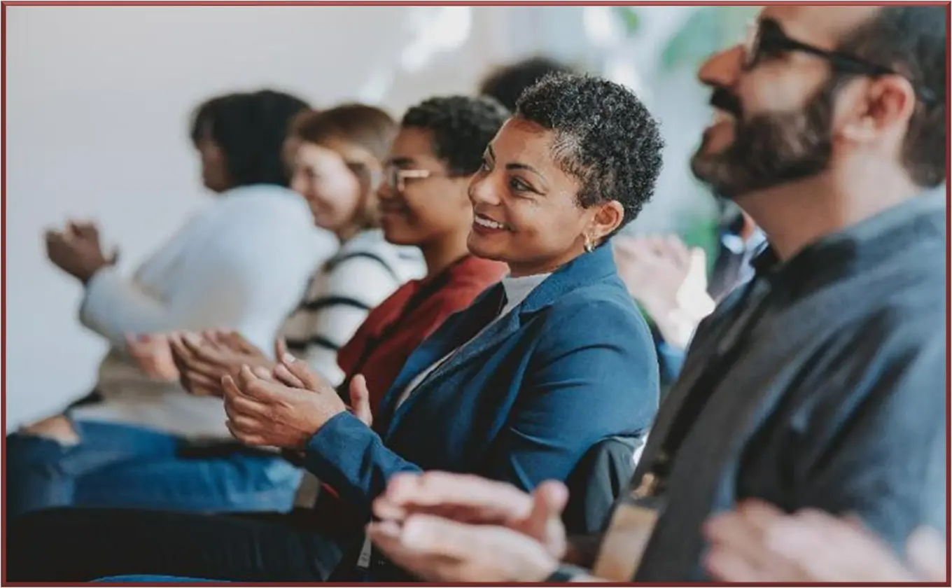 Women in group meeting smiling at presenter or presentation