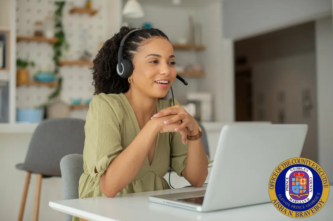 Woman in front of laptop on phone headset