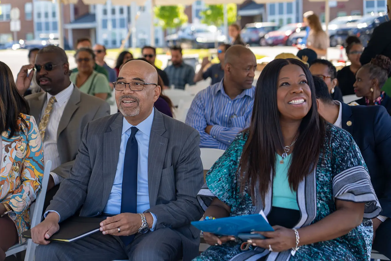Executive Director Perry Paylor sitting beside multiple individuals