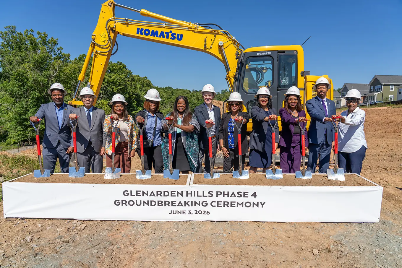 Glenarden Hills Phase 4 team of 11 individuals posing with shovels with an excavator behind them