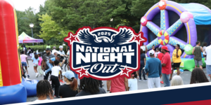 Festival featuring an air bounce machine, people walking, and kids playing.