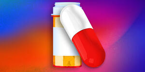 A pill bottle and a pill in front of a colorful background.