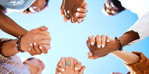Group of people holding hands in a circle 