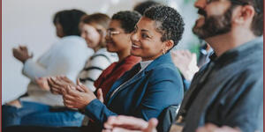 Women in group meeting smiling at presenter or presentation
