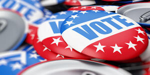 red, white, and blue pins with the word "vote"