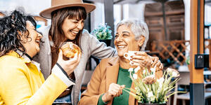 3 smiling women enjoying brunch