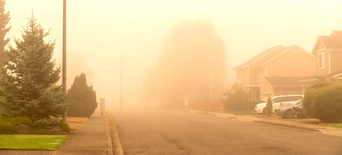 A neighborhood covered in the overcast of smog from forest fires causing the air quality to decrease.