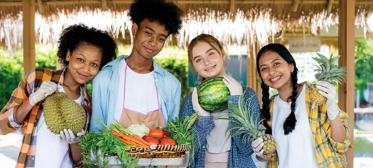 a group of teens holding different fruits in their hand